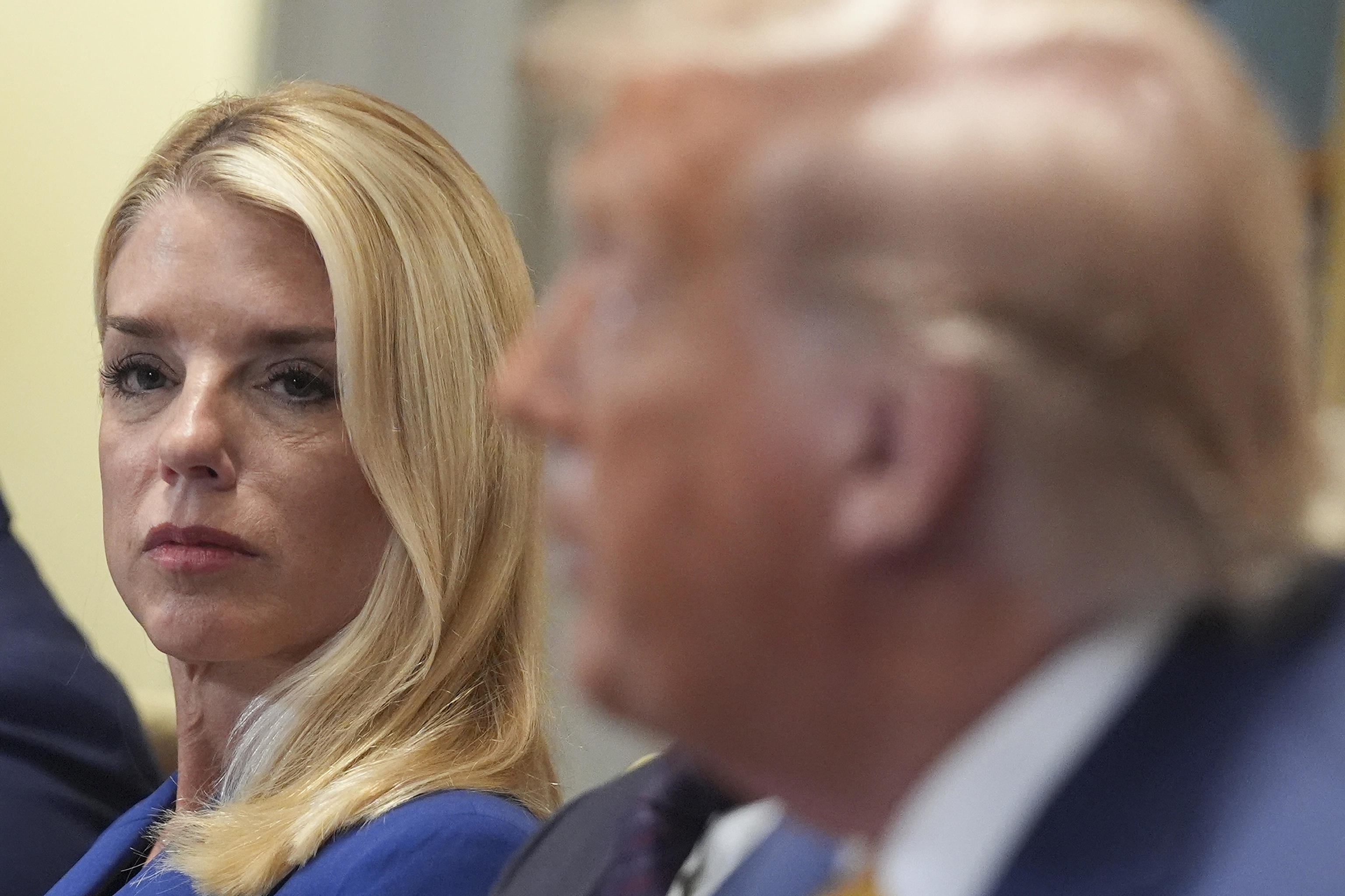 U.S. Attorney General Pam Bondi, left, listens to President Donald Trump.
