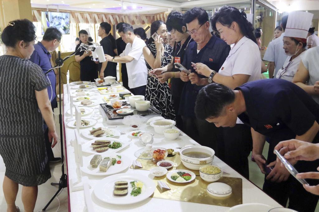 People look around the food featuring dog meat.