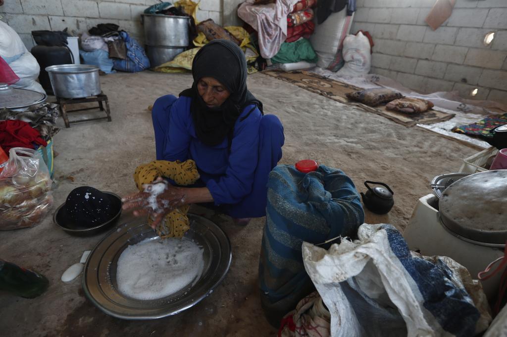 A displaced Bedouin woman washes clothes.