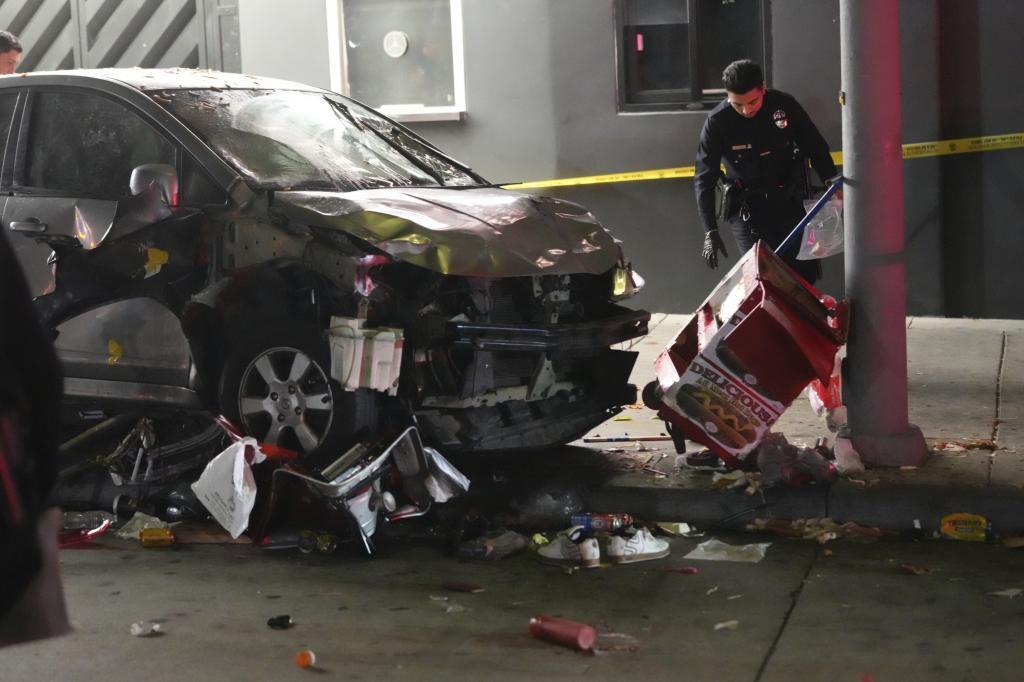 A vehicle sits on the sidewalk after ramming into a crowd of people.