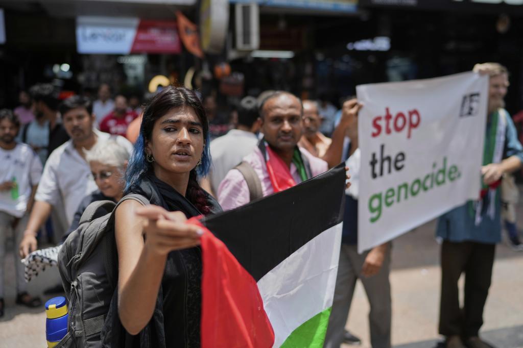 Activists hold banners and Palestinian flags.
