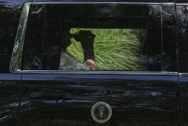 Donald Trump drinks while leaving a caravan at the Trump National Golf Club.