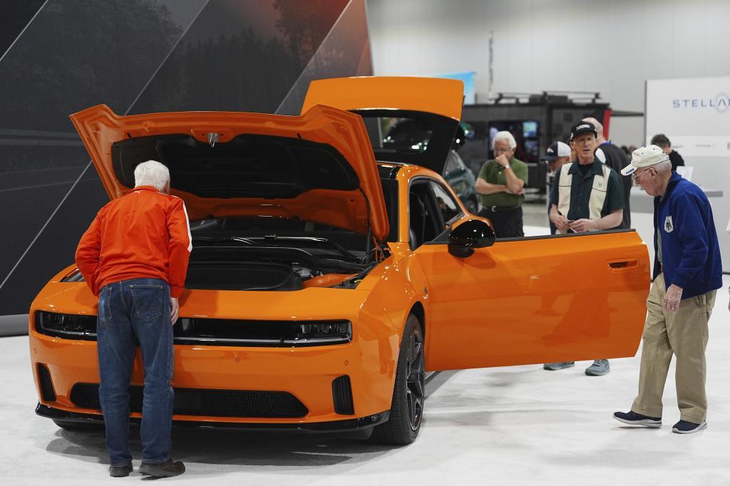 Shoppers look over a 2025 Dodge Charger Daytona.
