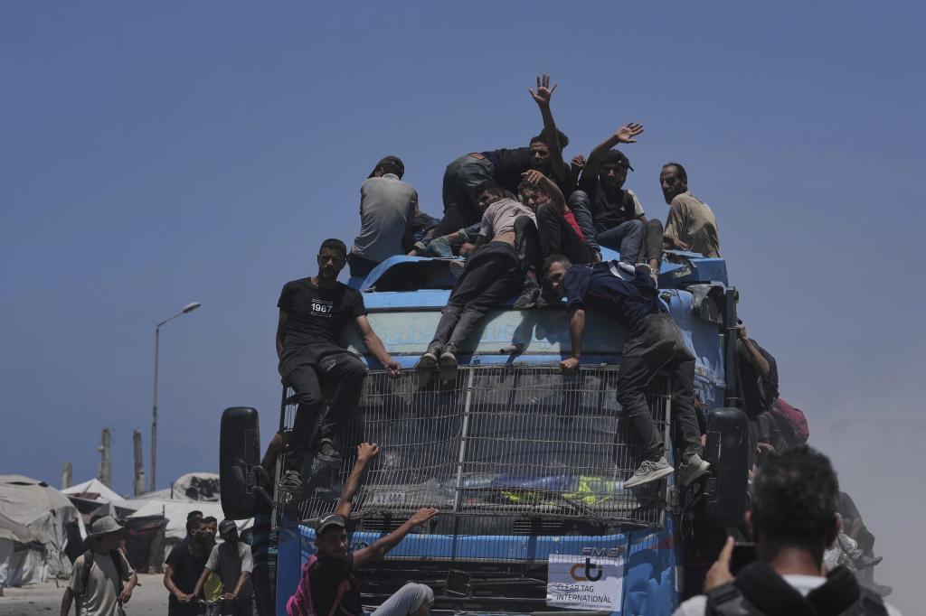 Palestinians hold onto an aid truck.