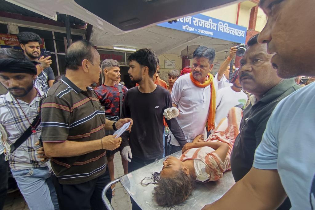 An injured from temple stampede is carried inside a hospital, Haridwar, India.