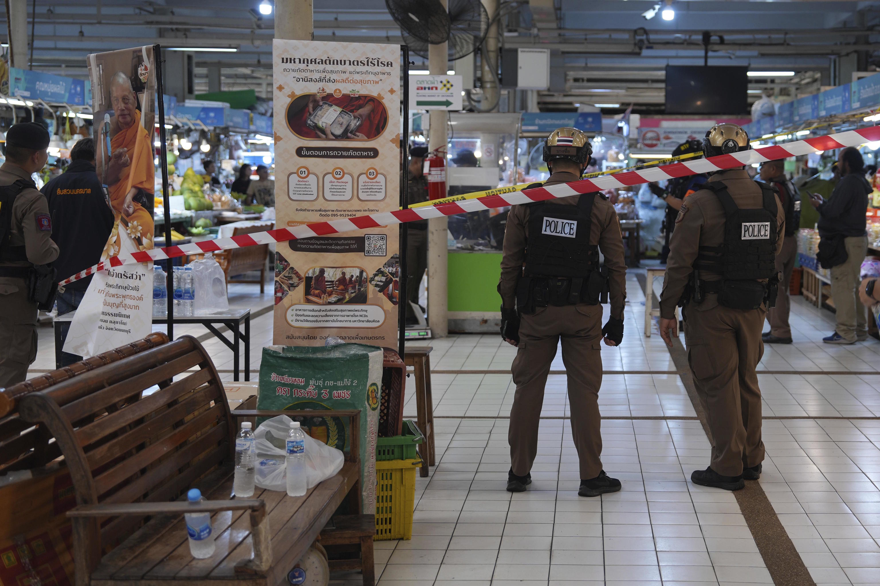 Policemen at a crime scene at a market in Bangkok.
