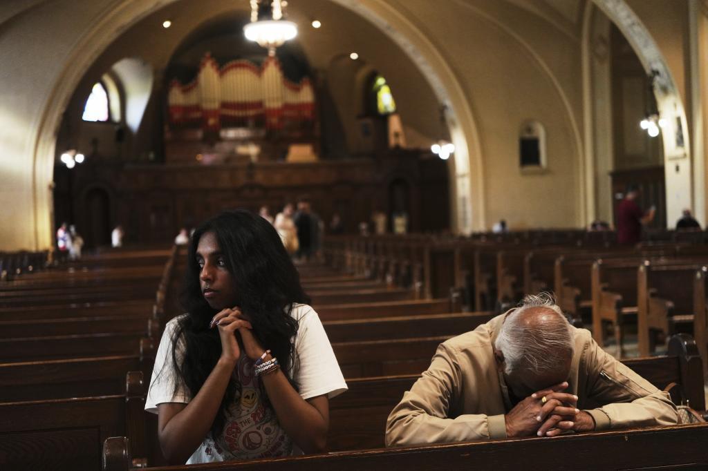 Thurvi Valli and her grandfather, Sitham Valli pray inside Crypt Church.
