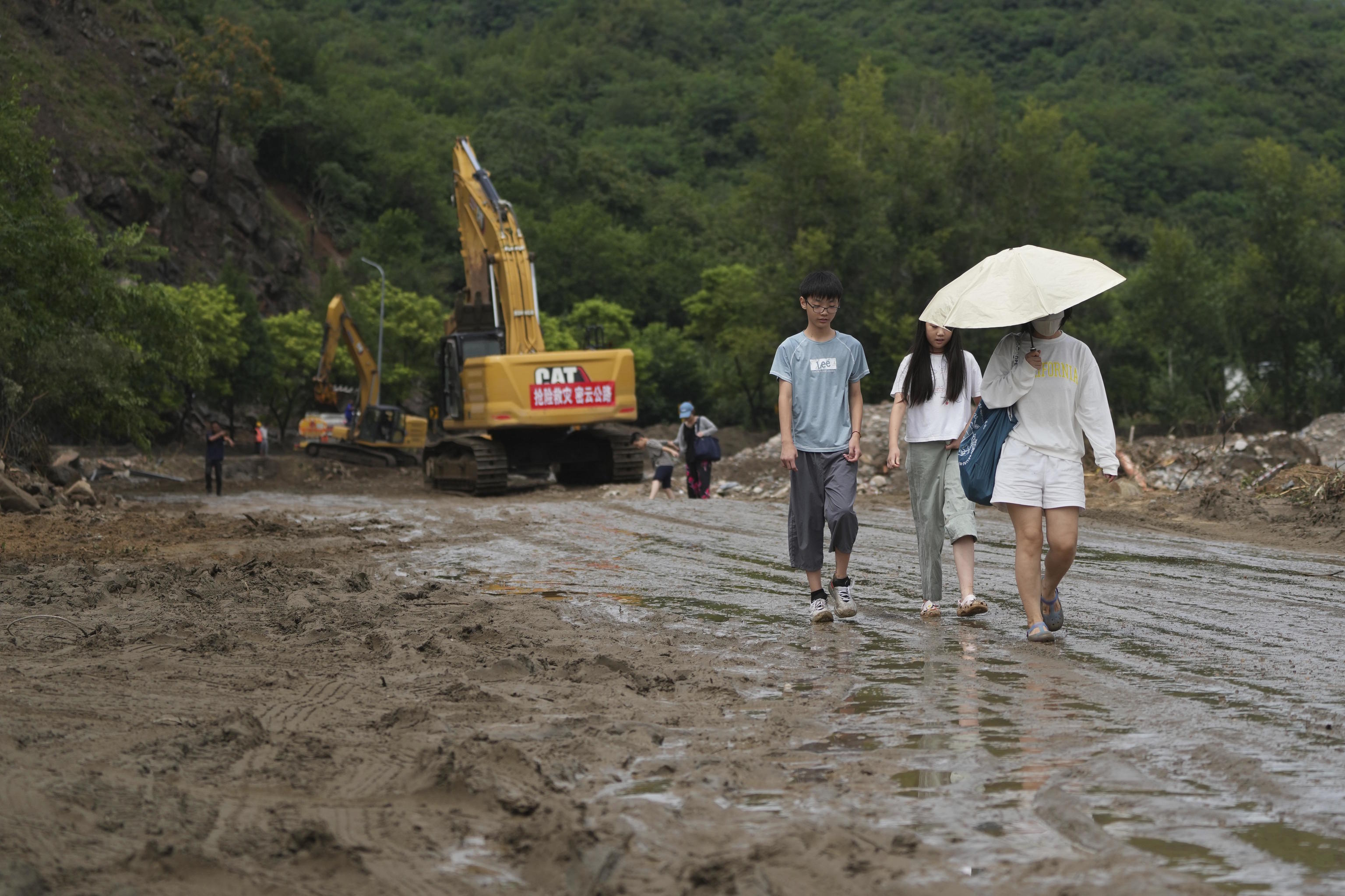 Damaged road covered with mud and debris after heavy rains in Miyun.