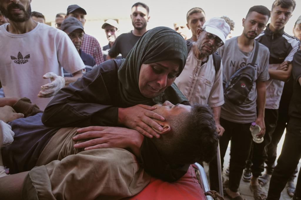 Nabila Al Shaer, center, mourns the body of her son, Jamil Al Shaer, 21.