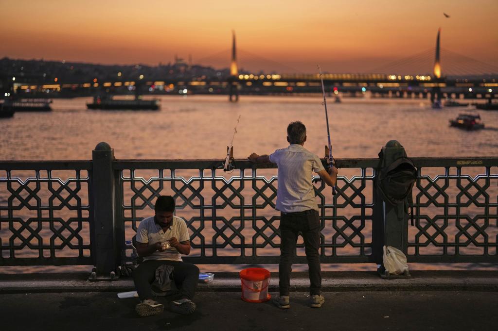 A man casts his line into the Bosphorus at Galata bridge.