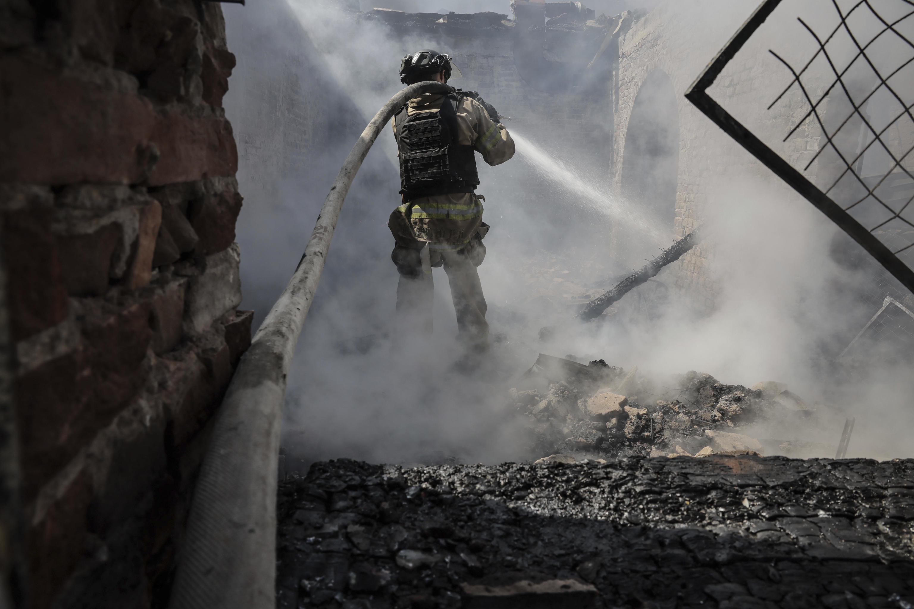 A firefighter works after a Russian attack.