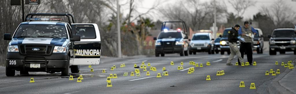 Forensic police officers work at the scene.