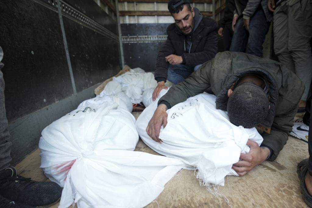 Palestinians mourn their relatives killed in the Israeli bombing of the Nusseirat refugee camp in the Gaza Strip at Al Aqsa Hospital
