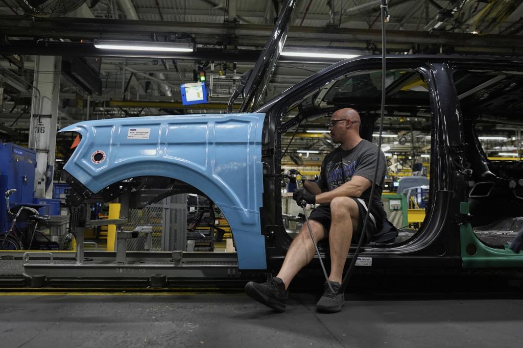 A vehicle assembly technician works on a 2025 Ford Expedition