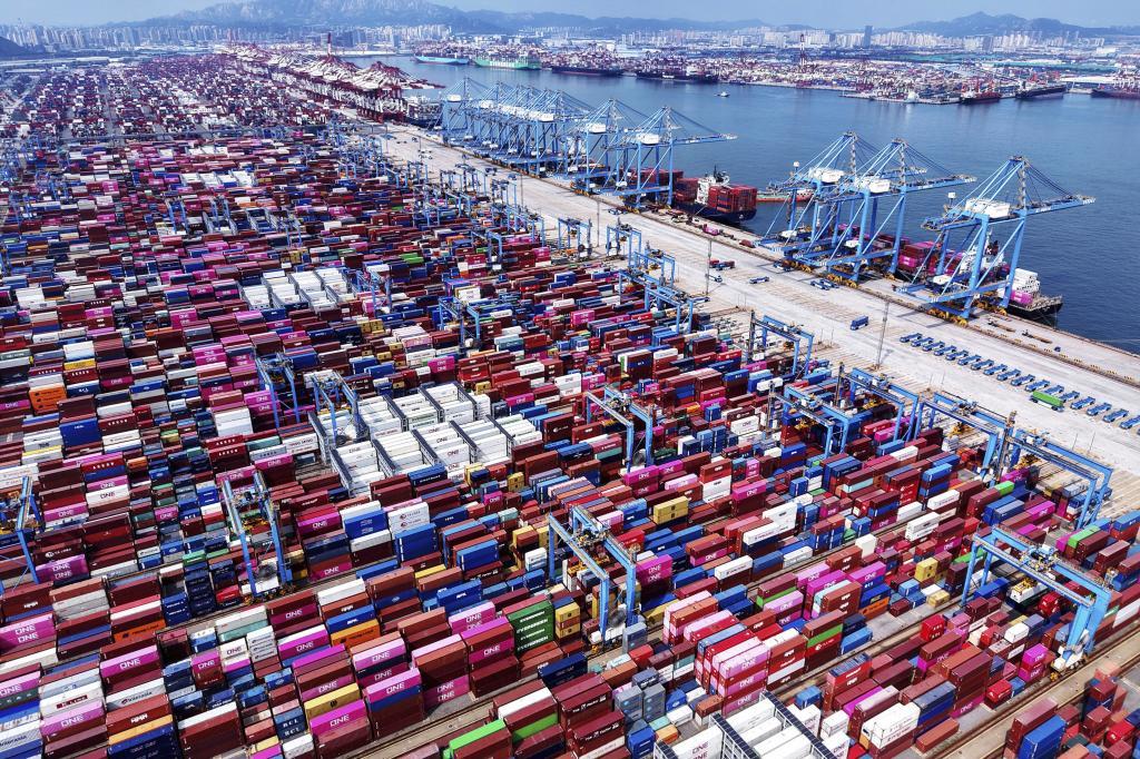 Cranes load containers and unload them from vessels at a container terminal in Qingdao in east China's Shandong province