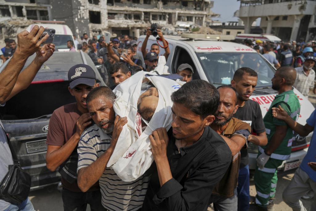 Palestinians carry the body of Al Jazeera journalist Mohamed Qreiqeh,