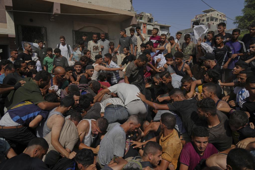 Palestinians struggle to collect humanitarian aid airdropped by parachutes into Gaza City