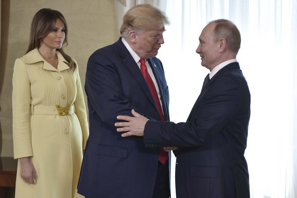 First lady Melania Trump, left, watches as President Donald Trump and Russian President Vladimir Putin