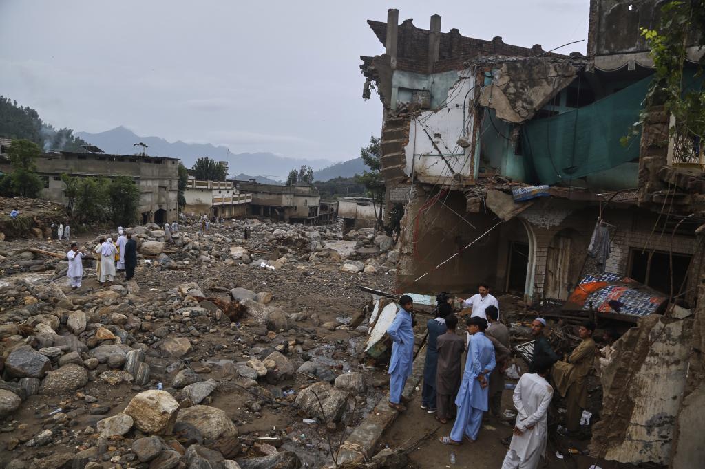 A local resident looks a damaged home following Friday's flash flooding at a neighborhood of Pir Baba