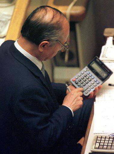 A stockbroker using a calculator.