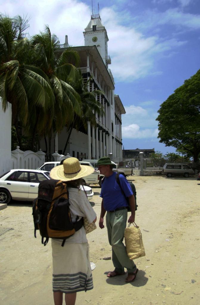 Two tourists in front of the Beit el Ajaib Palace in Stone Town, Zanzibar
