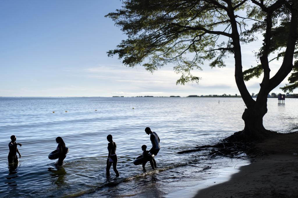 People wade into the waters of Lake Victoria