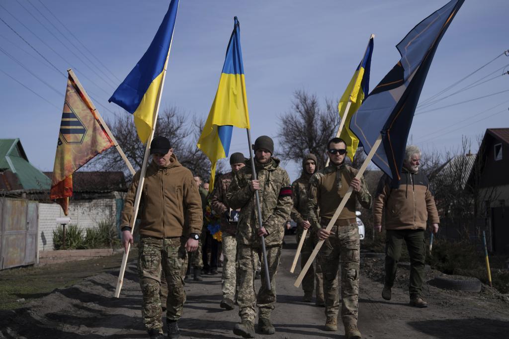 Ukrainian servicemen carry National flags and flags of 3rd Assault brigade