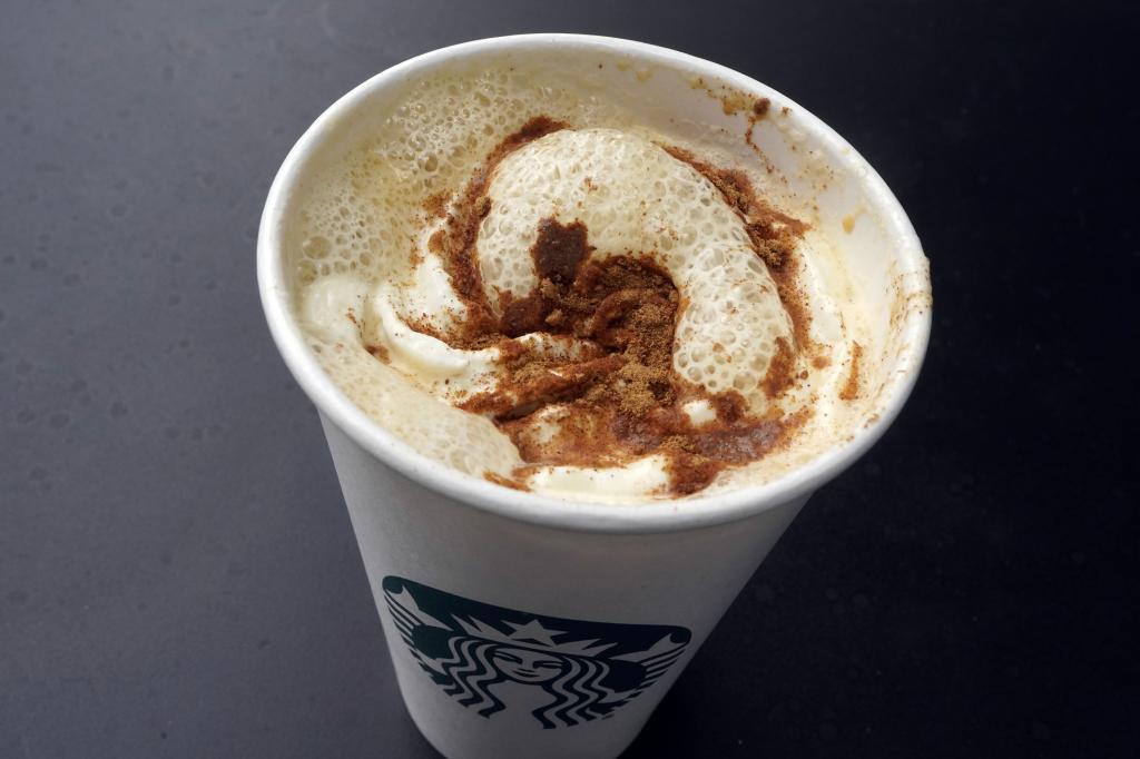 A Pumpkin Spice Latte drink rests on a table at a Starbucks