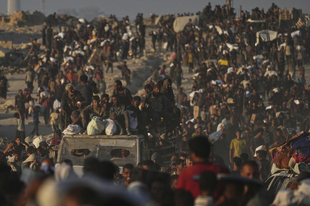 Palestinians carry sacks of flour unloaded from a humanitarian aid convoy that reached Gaza City