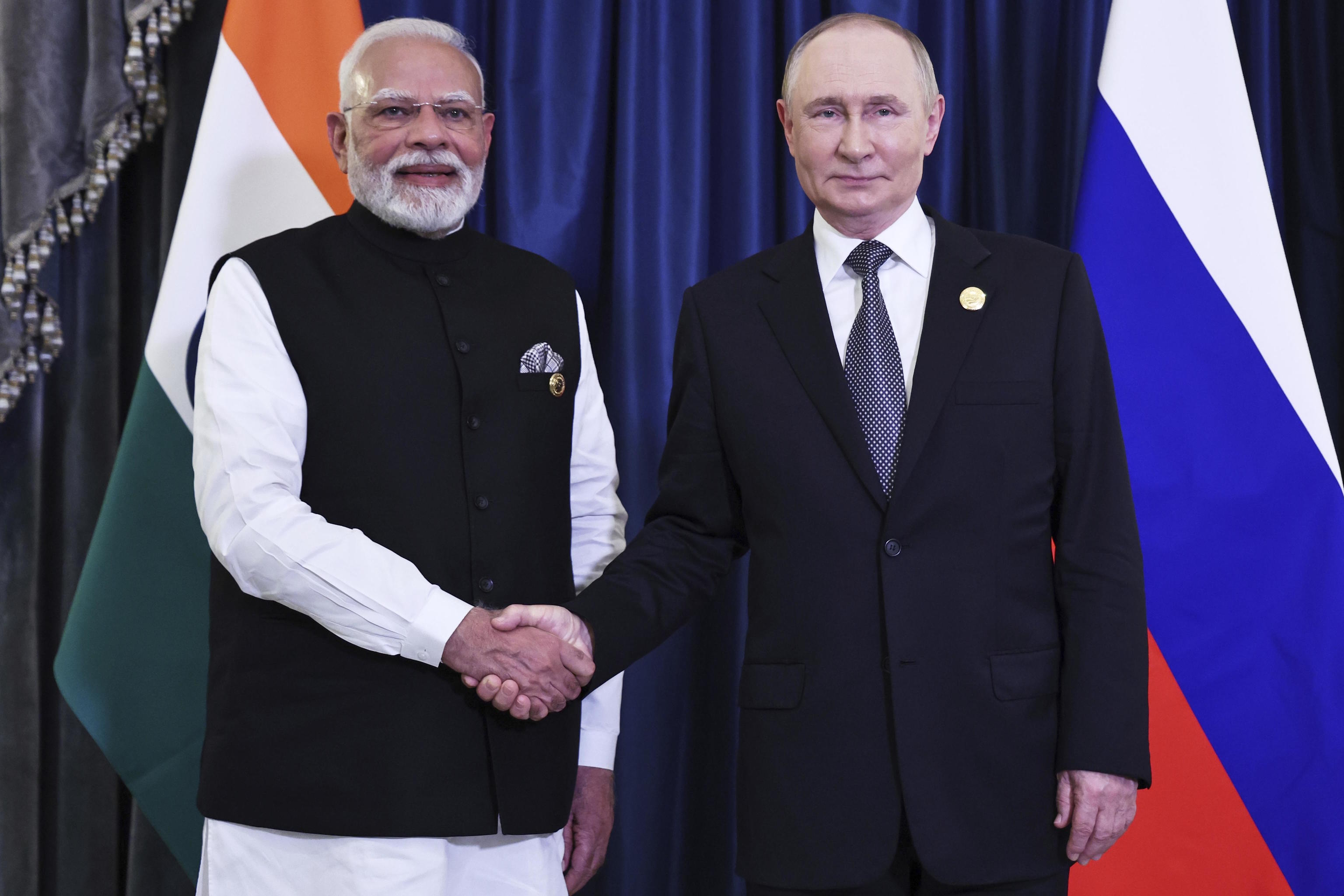 Indian Prime Minister Modi, left, and Russian President Putin shake hands.