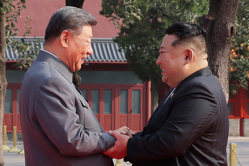North Korean leader Kim Jong Un, right, shake hands Chinese President Xi Jinping