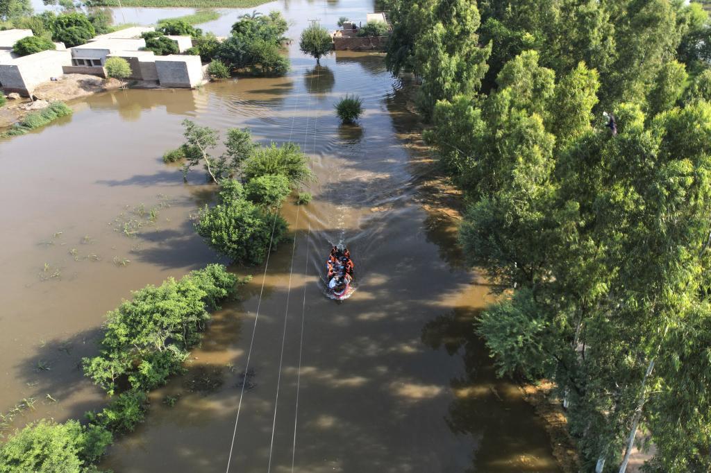 Rescue workers evacuate villagers from a flood hit area, in Tiba Gheal village