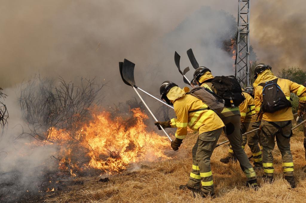 Firefighters battle a wildfire in Veiga das Meas, northwestern Spain