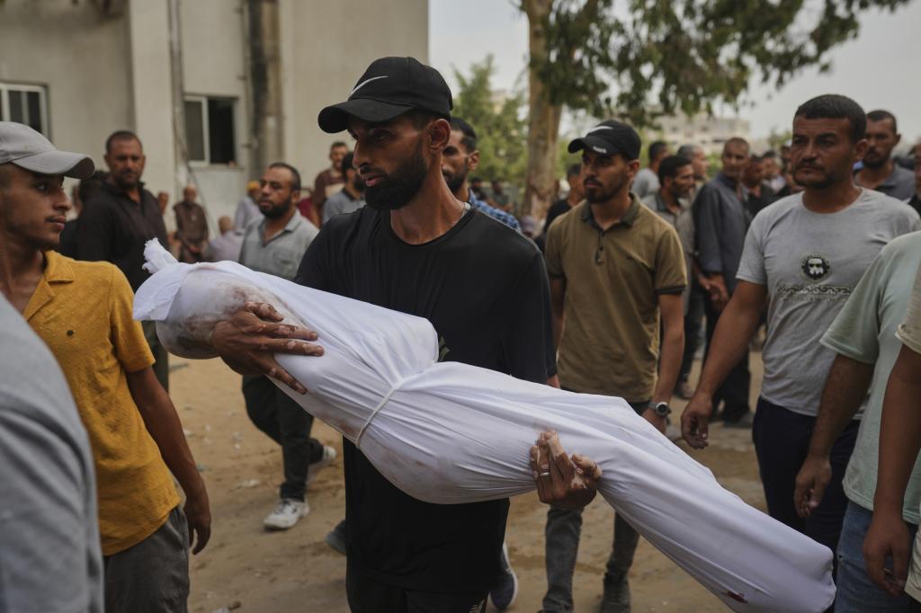 A relative carries the body of Palestinian child Muath Al-Basus