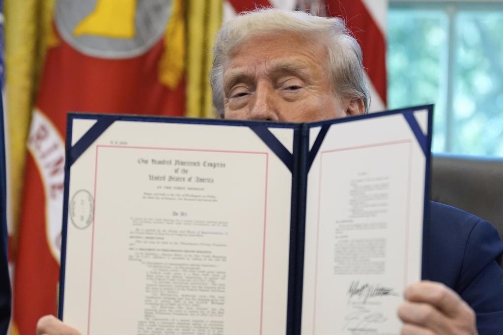 President Donald Trump holds a signed document regarding additional protection for homebuyers