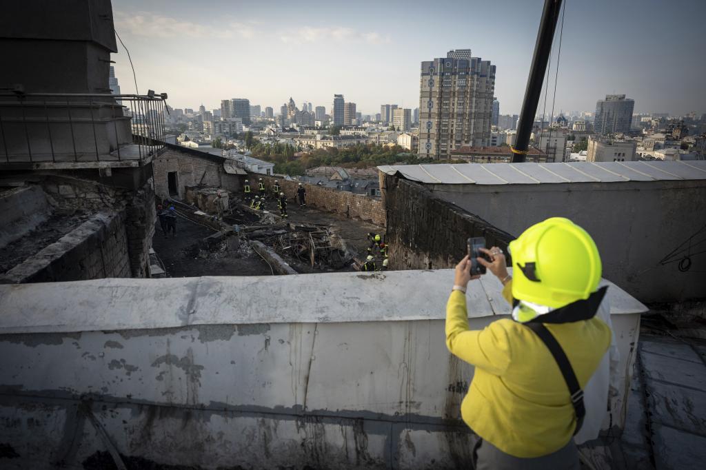 Rescue workers clear the rubble of the Cabinet of Ministers building damaged following a Russian attack in Kyiv