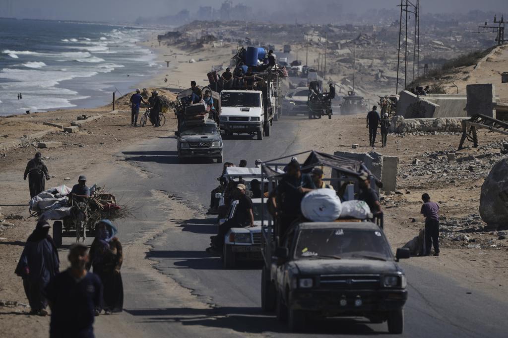 Displaced Palestinians fleeing northern Gaza carry their belongings along the coastal road toward southern Gaza