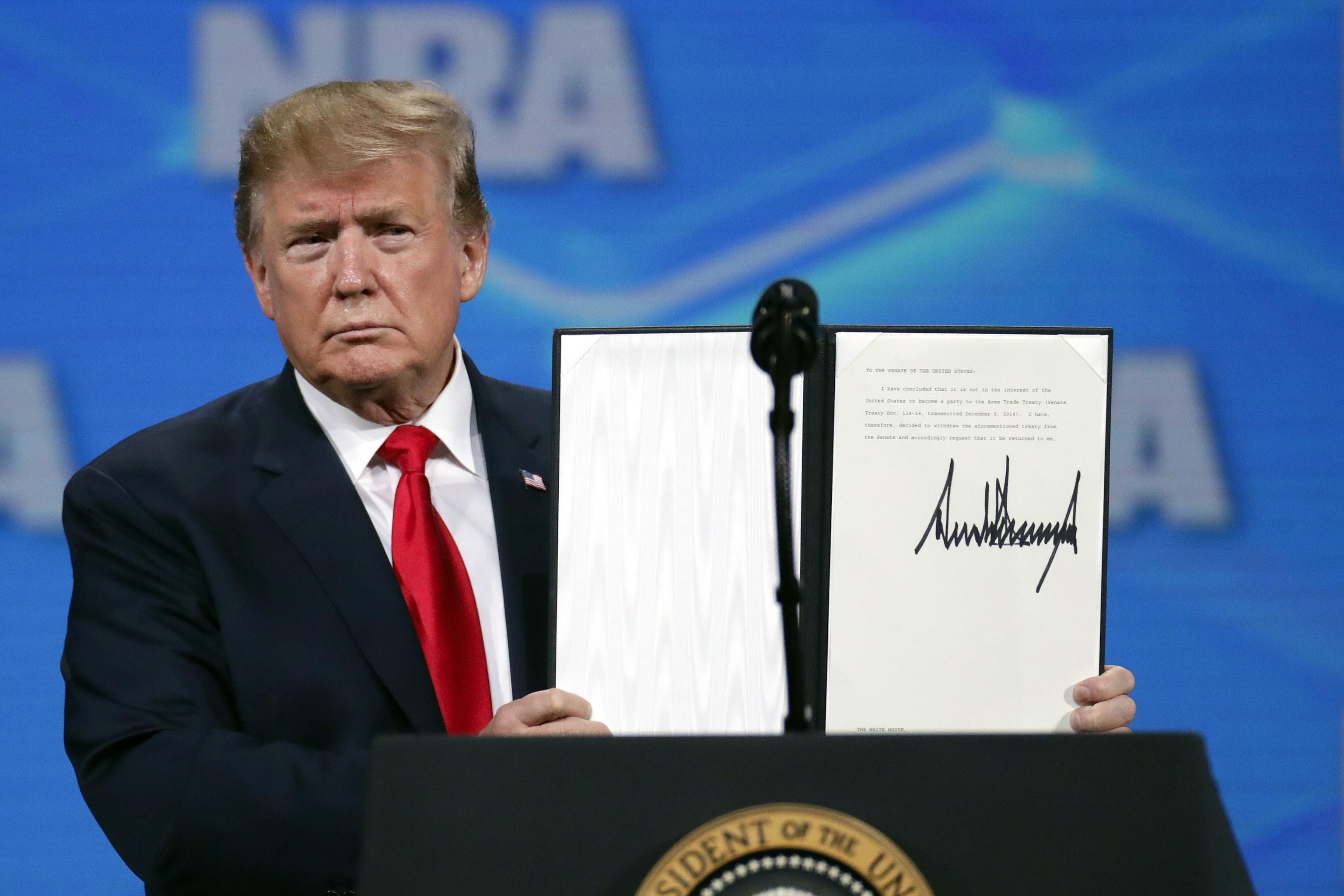 US President Donald Trump holds a document with his signature.