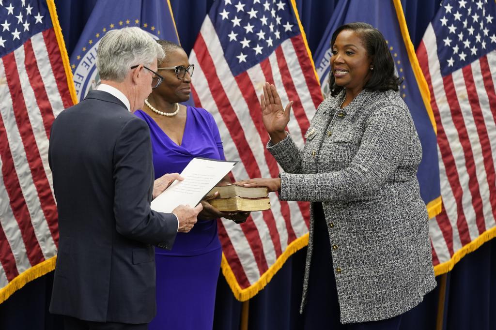 Lisa Cook, right, takes the oath of office to become a member of the Federal Reserve Board