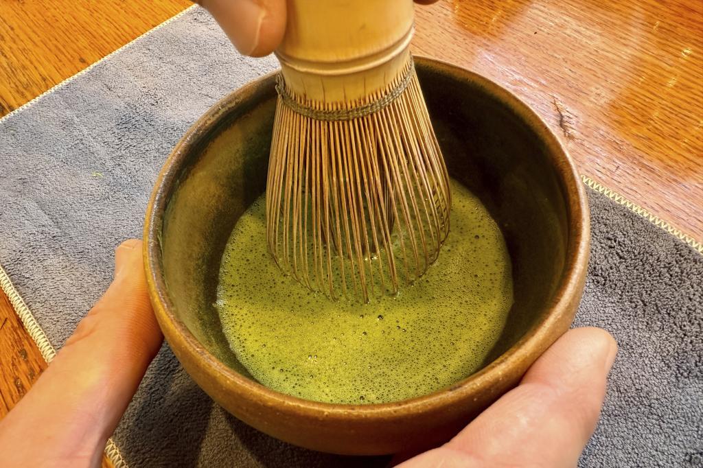 Senior Tea Buyer Aaron Vick uses a whisk to make a matcha drink