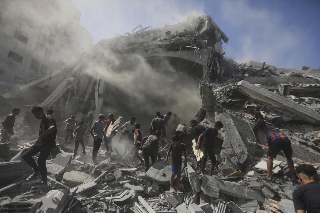 Palestinians search for wood to sell or use for cooking amid the rubble of a building