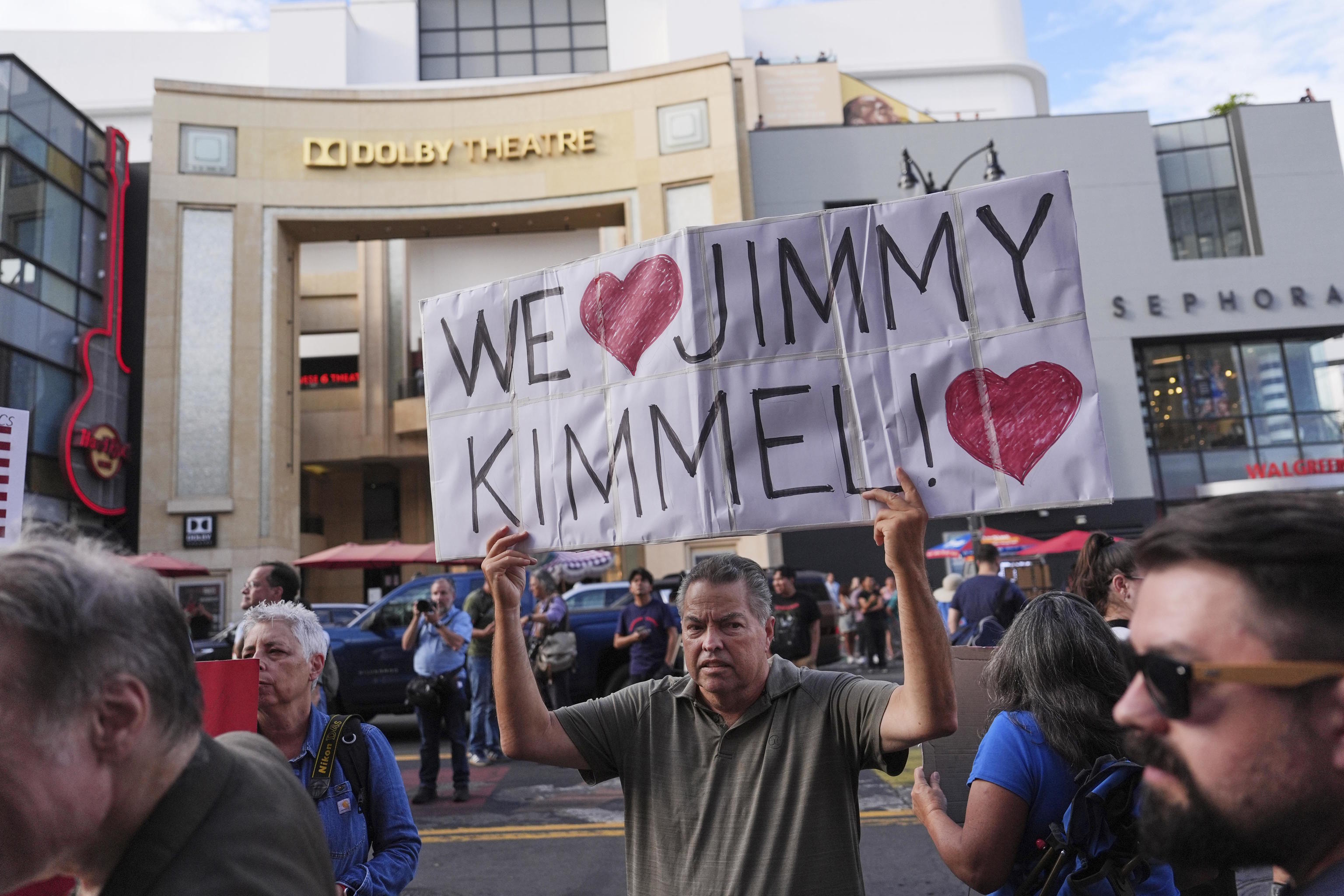A demonstrator holds a sign where the late-night show "Jimmy Kimmel Live!" is staged.