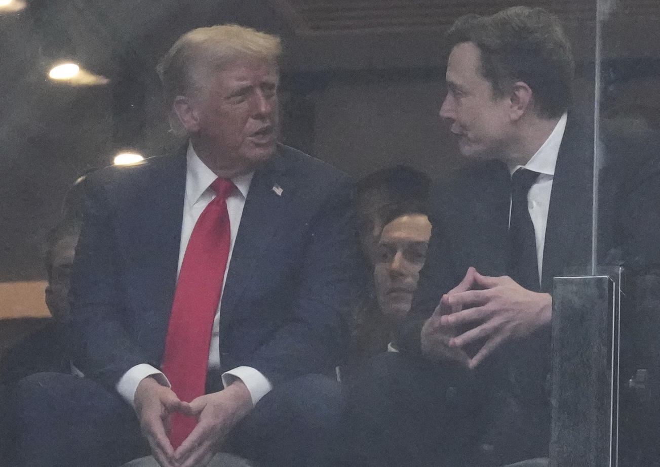 President Donald Trump, left, and Elon Musk talk during a memorial for Charlie Kirk.