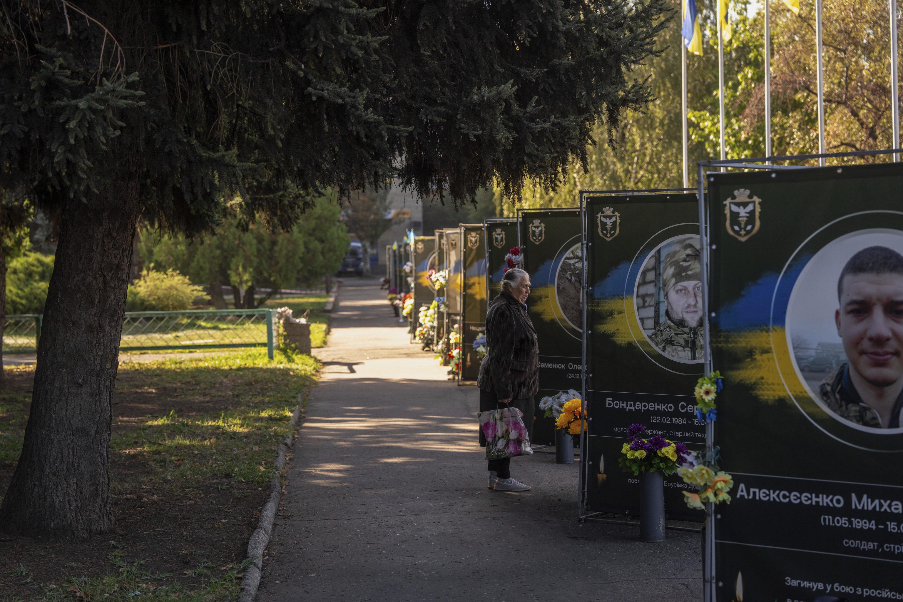 A woman looks at portraits of fallen servicemen in Donetsk region.