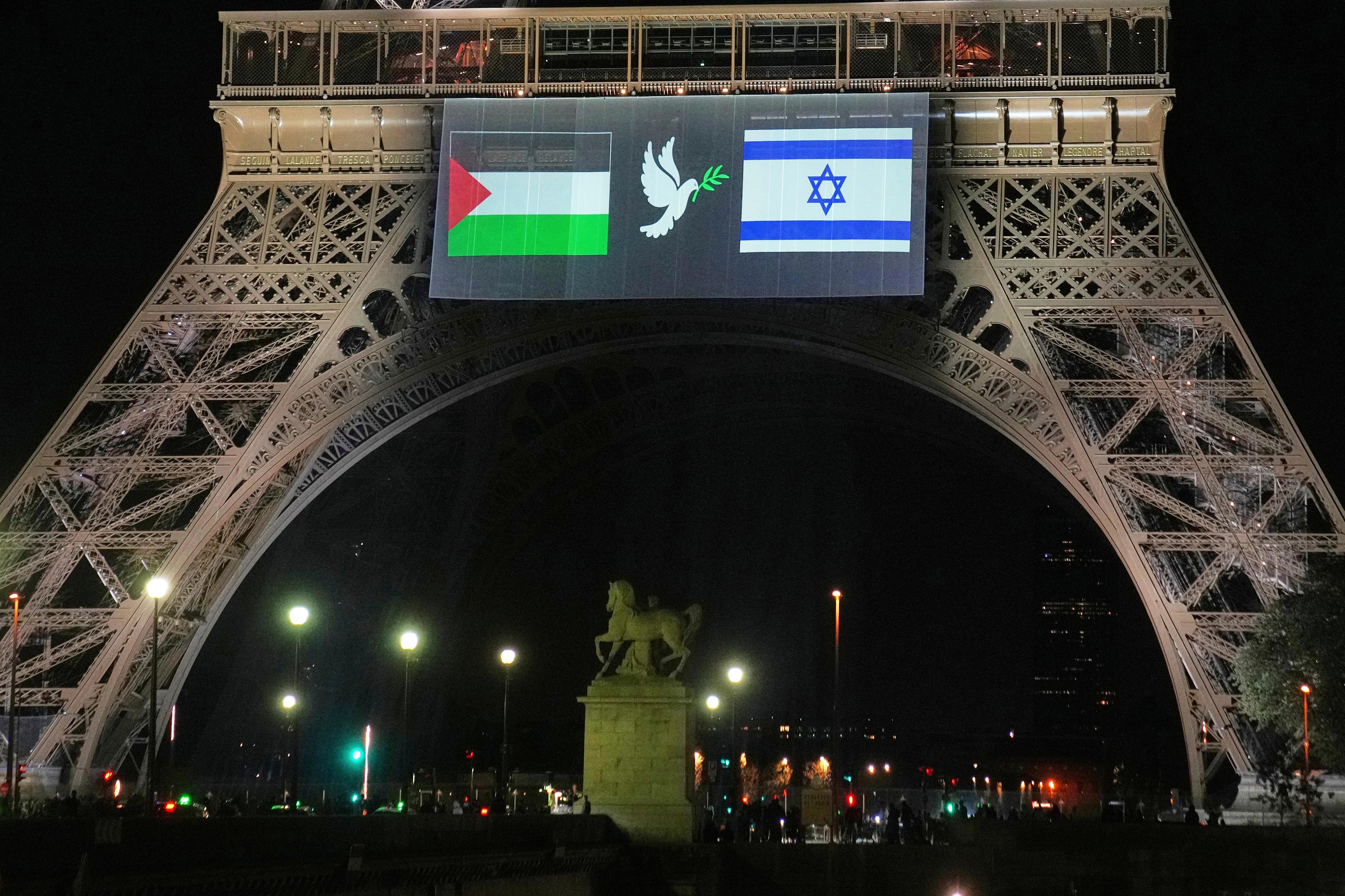 Palestinian and Israeli flags and a dove on the Eiffel Tower.