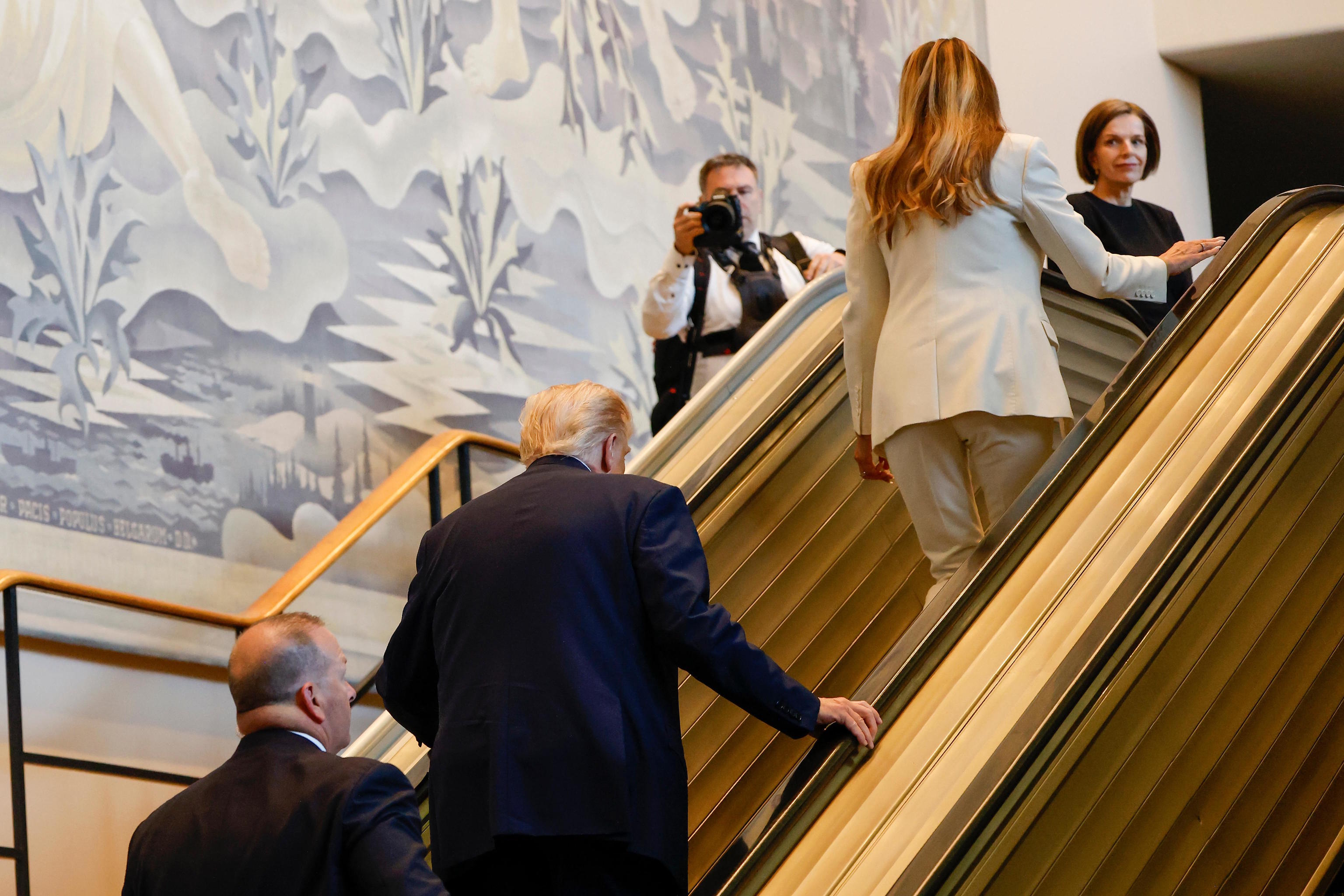 U.S. President Trump and First Lady ride the escalator after it stopped.