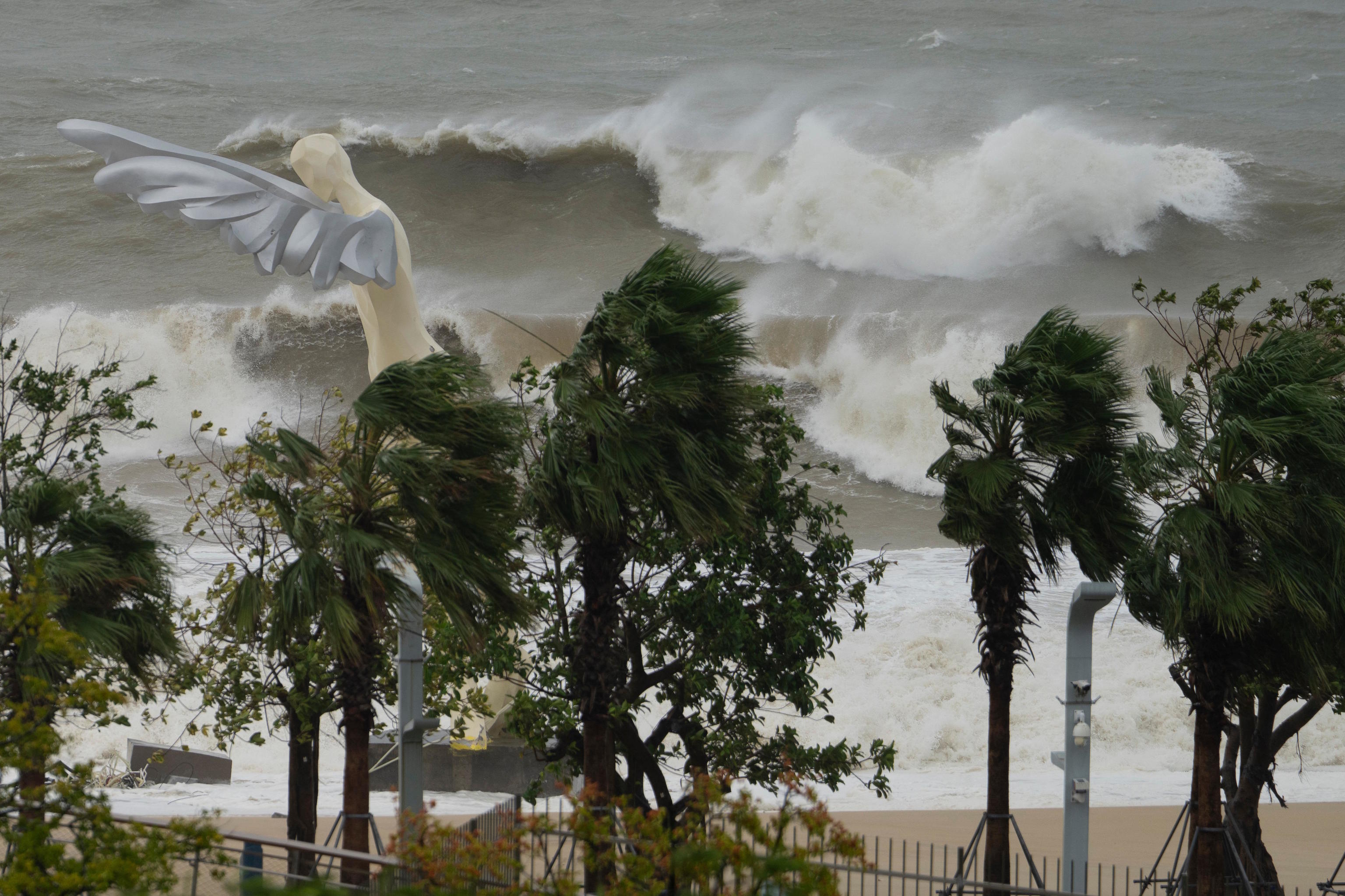 Waves crash onto a beach near a giant sculpture in Shenzhen in southern China's Guangdong province.