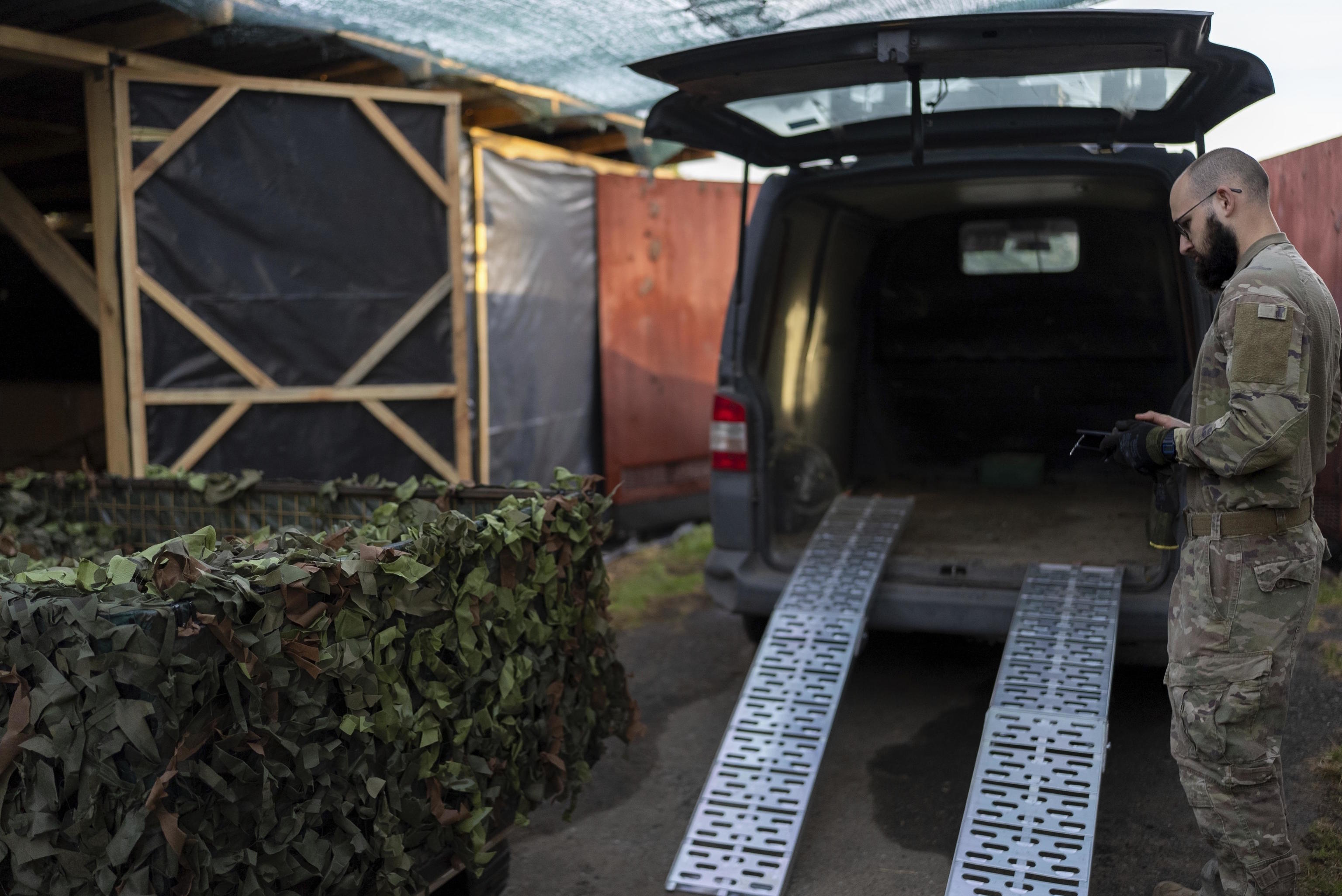 A Ukrainian serviceman known by call sign "Demis" loads a drone onto a car near the front line in Donetsk region.