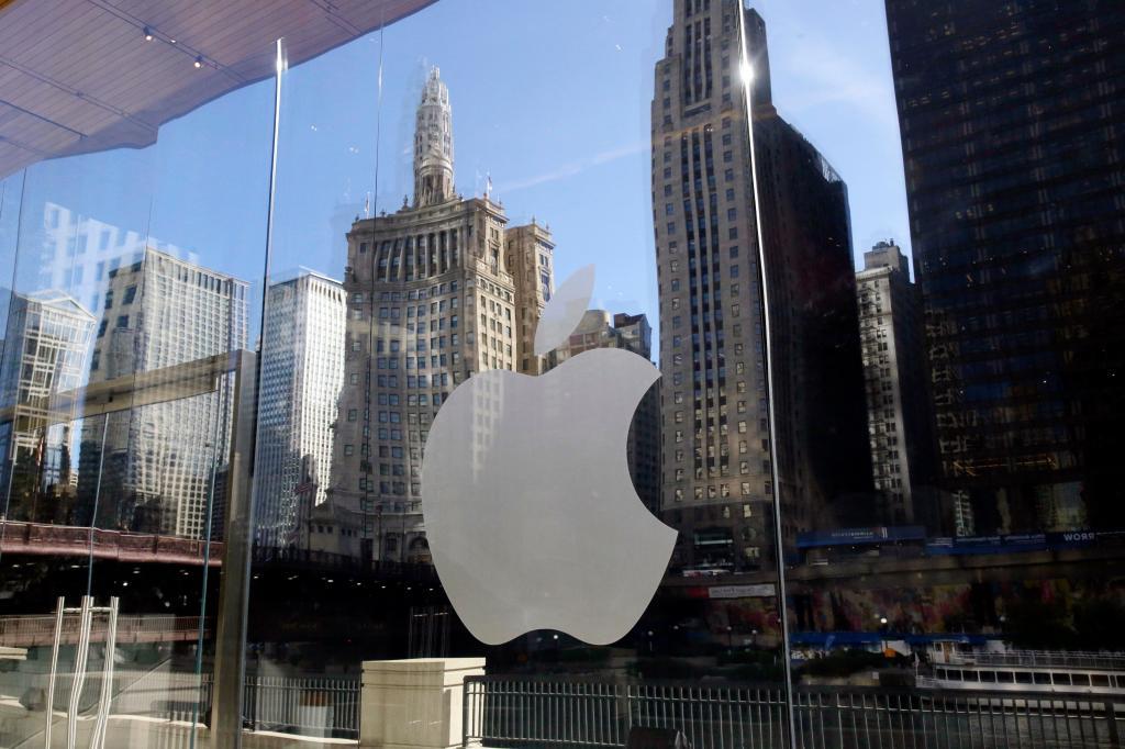 Buildings are reflected behind the logo at an Apple Store