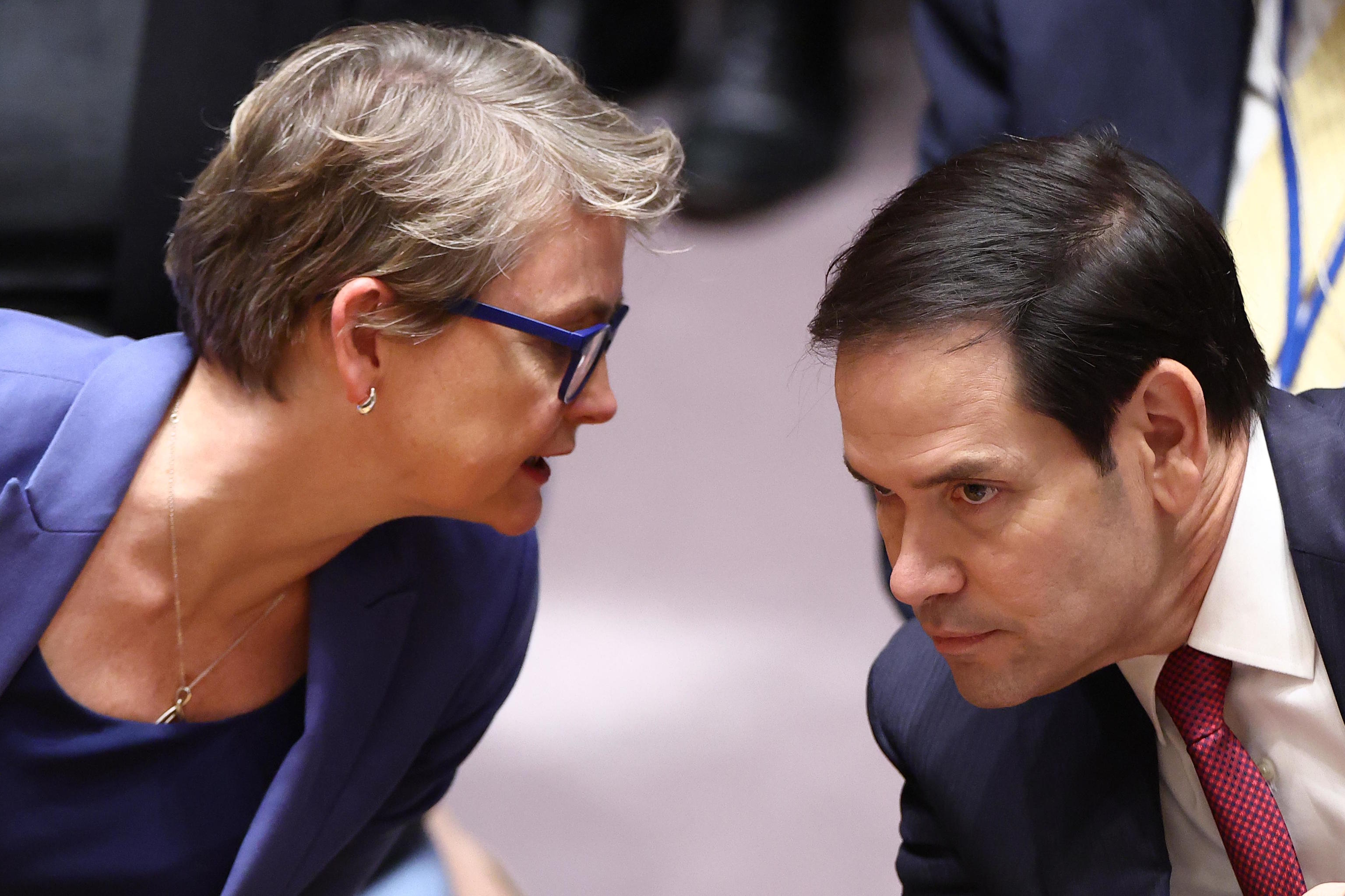 Marco Rubio leans over to listen to Britain's Foreign Secretary Yvette Cooper.